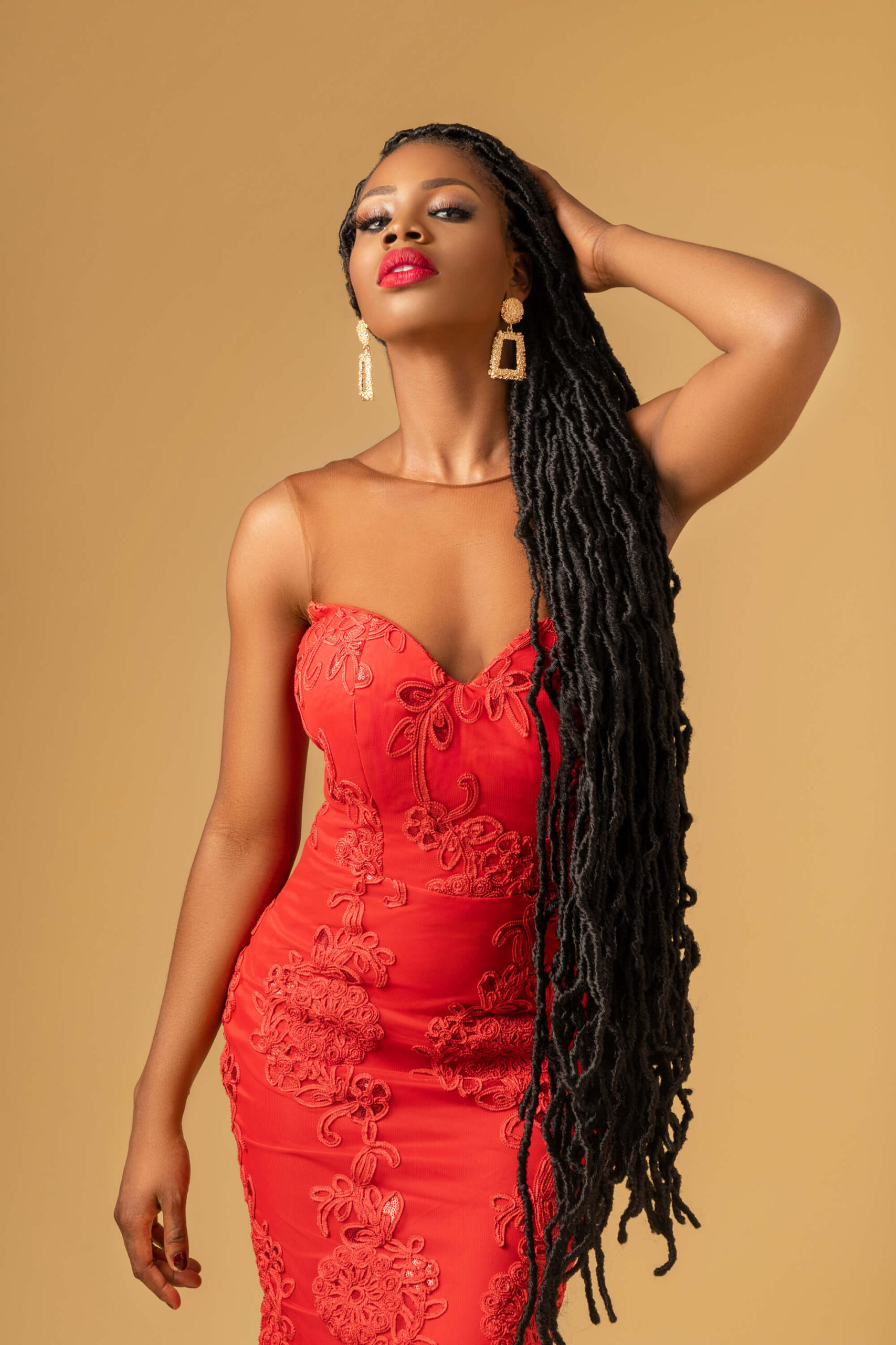 "Stunning portrait of a woman in a vibrant red dress, exuding confidence and elegance in a beautiful and captivating image."